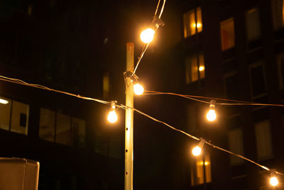 Low angle view of illuminated street lights at night