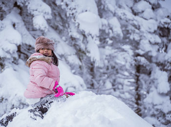 Portrait of young woman sitting on snow