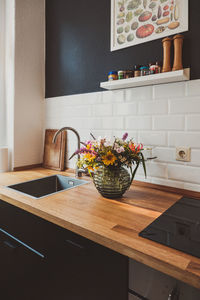 Flower vase on wooden kitchen counter at home