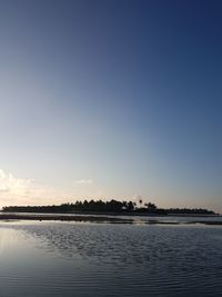 Scenic view of lake against clear blue sky