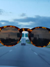 Close-up of sunglasses against sky