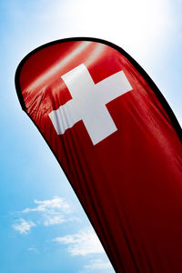 Low angle view of swiss flag against sky