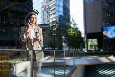 Young woman using mobile phone in city