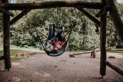 Young female friends enjoying on swing at playground