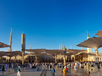 Group of people in temple against clear blue sky