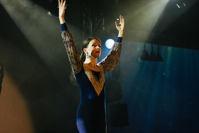 Woman standing with arms raised