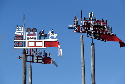 Low angle view of information sign against clear blue sky