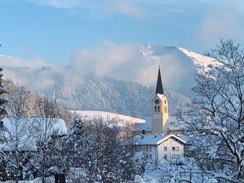 Church and buildings against sky during winter