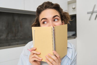 Portrait of smiling young woman reading map