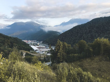 Scenic view of townscape by mountains against sky