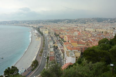 High angle view of townscape by sea against sky