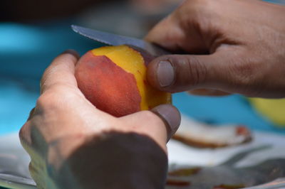 Someone peels a nectarine