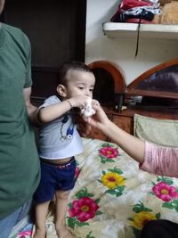 Full length of mother and baby girl standing in kitchen