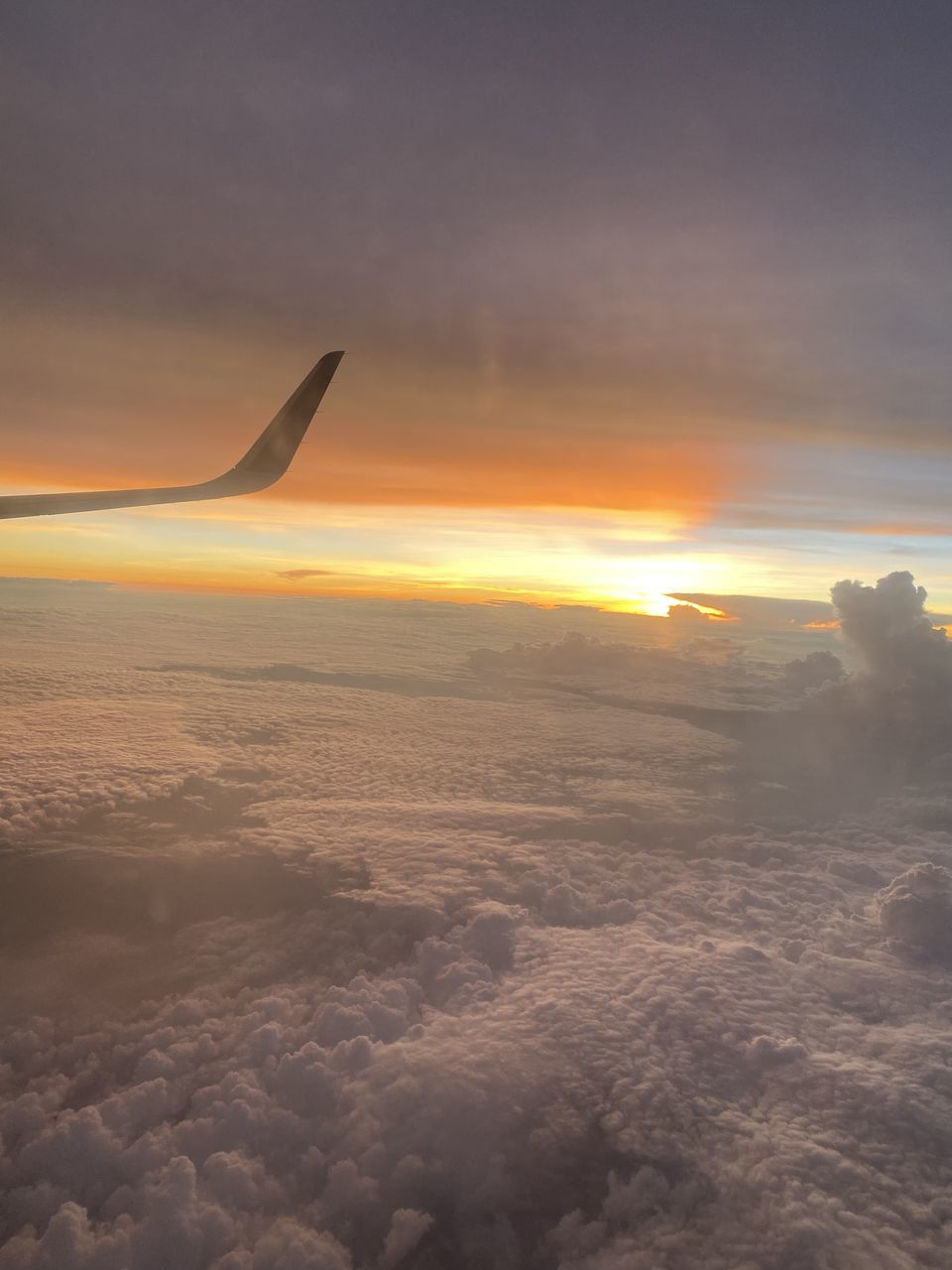 AIRPLANE FLYING OVER SEA DURING SUNSET