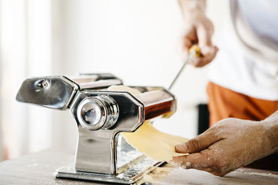 Midsection of male chef making food with machinery on table
