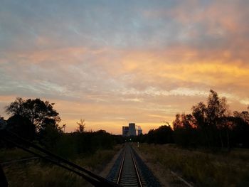 Railroad tracks against sky during sunset