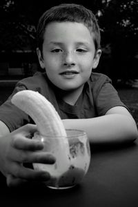 Portrait of boy holding ice cream on table