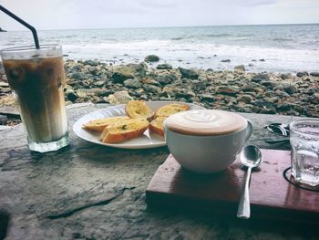 Coffee cup on table by sea