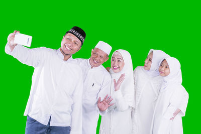 Portrait of people standing against colored background