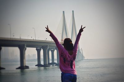 Woman standing by sea against clear sky