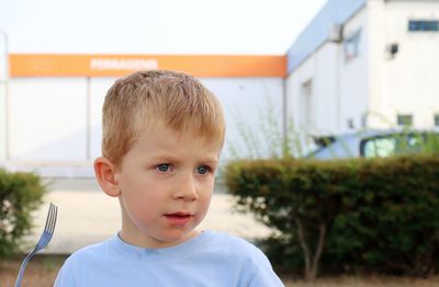 A blond boy with a dirty mouth and a fork in his hand. thoughtful five-year-old boy.