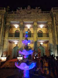 People in illuminated building at night