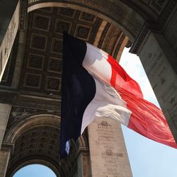Low angle view of french flag waving in historic building
