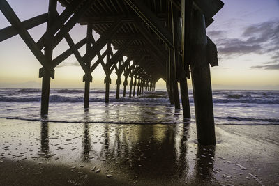 Pier over sea against sky during sunset