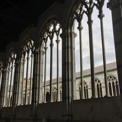 Low angle view of columns in old historic building against cloudy sky