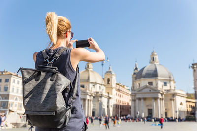 Rear view of woman in front of building