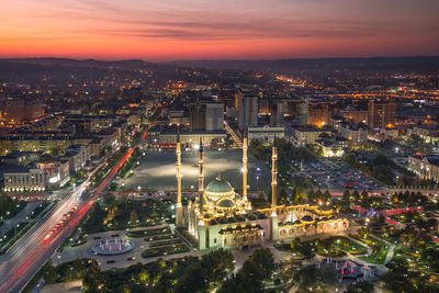 High angle view of illuminated city buildings during sunset