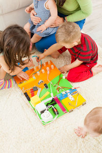 High angle view of siblings playing with toy