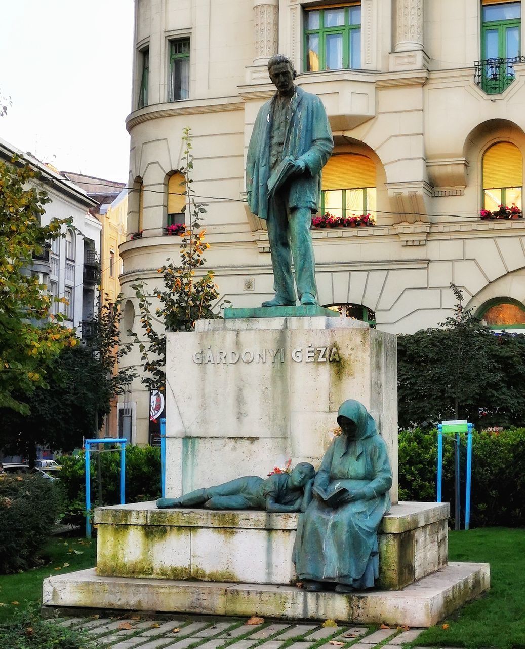 STATUE AGAINST TREES AND BUILDING