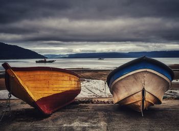 Boat moored on beach against sky