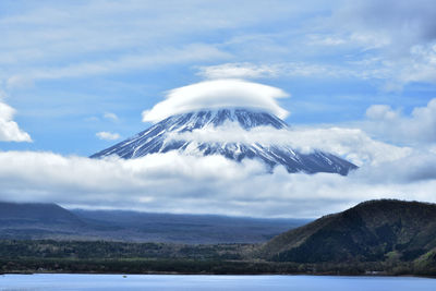 Scenic view of sea and mountains against sky