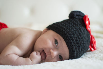 Close-up portrait of cute baby lying down on bed