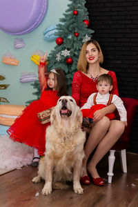 Portrait of young woman with dog on floor at home