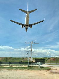 Low angle view of airplane flying against sky