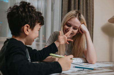 Mom and son are doing homework. sister helps brother solve math. home schooling. high quality photo