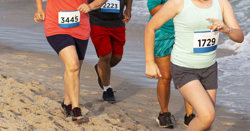 Low section of people running on beach