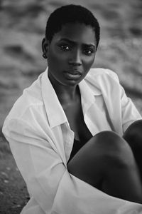 Portrait of young woman sitting on land