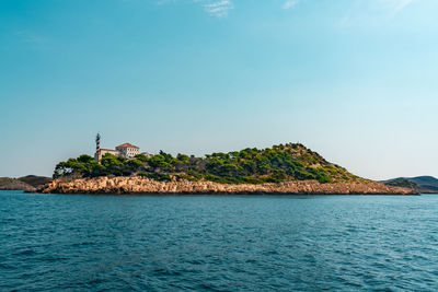 Scenic view of sea and lighthouse island against sky 