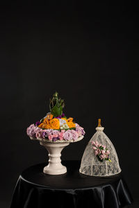 Decoration on cakestand at table against black background
