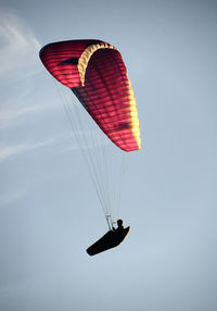 Low angle view of person paragliding against sky