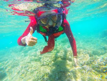 Young woman gesturing while snorkeling undersea