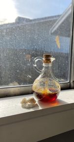 Close-up of honey pitcher on glass window