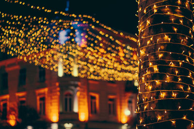 Low angle view of illuminated lanterns hanging outside building at night