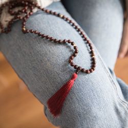 Midsection of woman with necklace at home