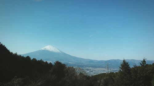 Scenic view of snowcapped mountains against clear blue sky