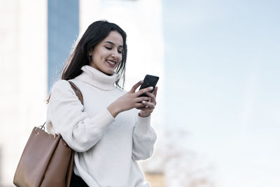 Smiling woman tex ting on phone